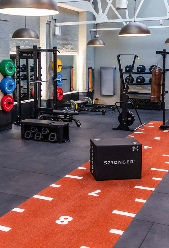 Interior Gym design with free weights area, rubber gym flooring and  cardio equipment by Stronger Wellness UK 